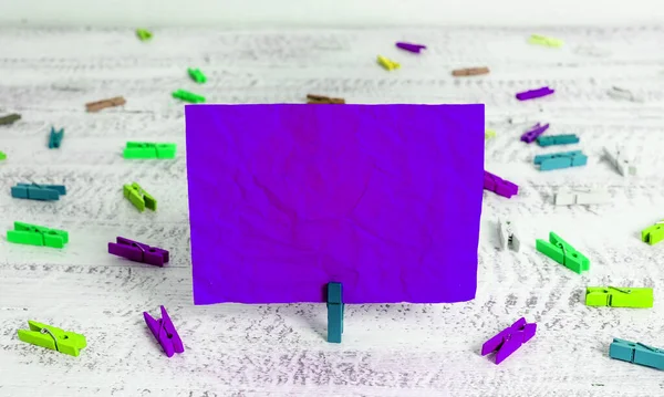 Rechteck Quadrat geformtes farbiges Papier mit Wäscheklammer oder Papierkugel in einem hellen Hintergrund. Bunt zerknitterte Notizen verteilen sich auf dem Tisch. Bürobedarf in einem Schreibtisch. — Stockfoto