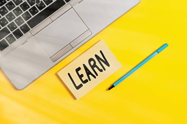 El yazısı metni yazmayı öğren. Mevcut yeni modifiye bilgi davranışları edinme kavramının anlamı: Trendi gümüş rengi açık dizüstü bilgisayar kare yapışkan not defteri işaretleyici renkli arkaplan.