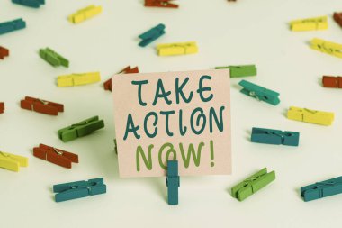 Take Action Now 'ı gösteren bir not yazıyorum. İş fotoğrafı gösterimi Hemen cevap verin Acilen bir şeyler yapılmalı Renkli çamaşır iğnesi kağıtları boş hatırlatıcı beyaz zemin arka plan ofisi
