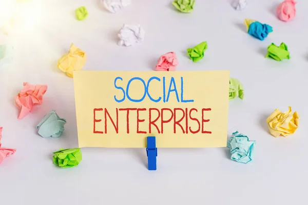 Konzeptionelle Handschrift, die Social Enterprise zeigt. Business photo showcasing Es ist ein Unternehmen, das bestimmte zivile Ziele verfolgt Farbiges zerknülltes Papier leere Erinnerung weiße Fußbodenklammer. — Stockfoto