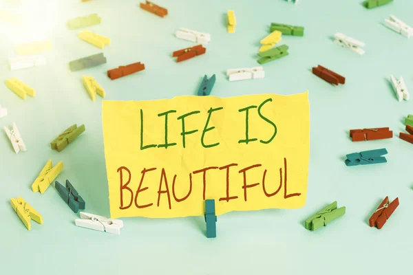 Handschrift tekst schrijven Life Is Beautiful. Concept betekenis Ga naar avontuurlijke vakantie, genieten en ontspannen om de natuur elk moment tevreden te stellen Kleurrijke wasknijpers lege herinnering blauwe vloer achtergrond — Stockfoto