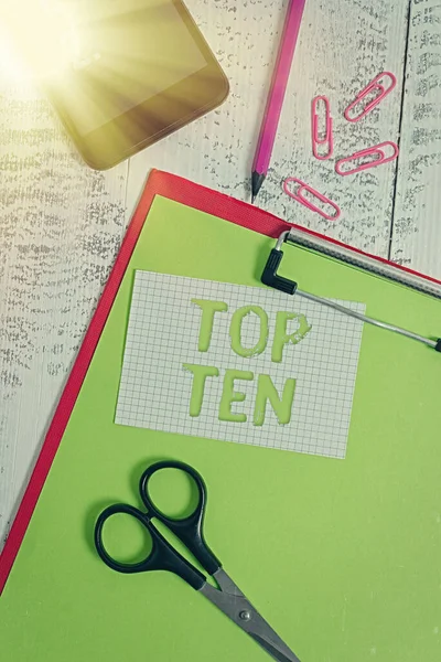 Text sign showing Top Ten. Conceptual photo items that are listed as the most popular and successful arranged in order Clipboard sheet pencil smartphone scissors note clips wooden background. — Stock Photo, Image