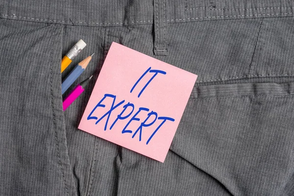 Conceptual hand writing showing It Expert. Business photo text expertise when dealing with database system, and technology Writing equipment and pink note paper inside pocket of trousers. — Stock Photo, Image