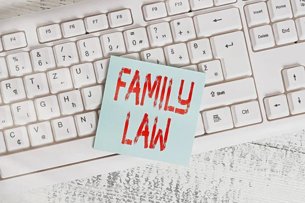 家族法を示す概念的な手書き。家庭内の問題を扱う法的慣行のボディを紹介するビジネス写真キーボードオフィス用品長方形の形状の紙リマインダー木材. — ストック写真