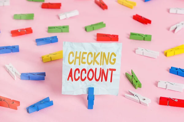 Writing note showing Checking Account. Business photo showcasing transactional bank charge used to debit all the expenses Colored clothespin papers empty reminder pink floor office pin.