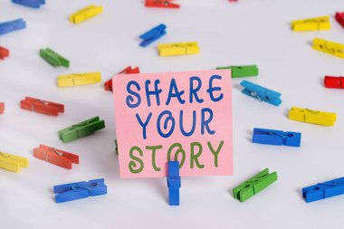 Hikayeni Paylaş 'ı gösteren bir not yazıyorum. İş fotoğrafı sergisi hayattaki önemli hayat tecrübenizi ve başarınızı gösterir Renkli çamaşır iğnesi kağıtları boş hatırlatıcı beyaz zemin arka plan ofisi.