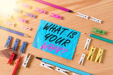 Conceptual hand writing showing What Is Your Why Question. Business photo showcasing asking someone about their purpose in life Colored crumpled papers wooden floor background clothespin. clipart
