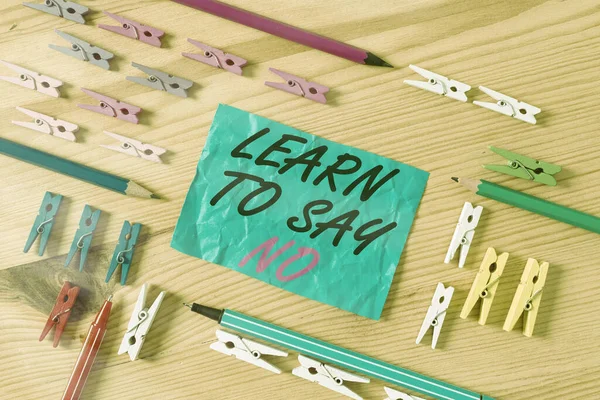 Conceptual hand writing showing Learn To Say No. Business photo showcasing selfjudgment and being in control of your work life Colored crumpled papers wooden floor background clothespin.