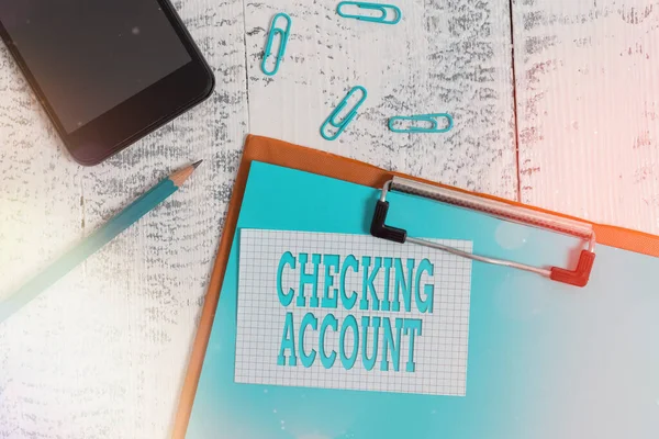 Handschrift tekst schrijven Checking Account. Concept betekent transactionele bankkosten gebruikt voor het debiteren van alle kosten Klembord papier vel potlood nota clips smartphone oude houten achtergrond. — Stockfoto