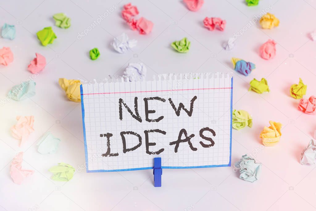 Word writing text New Ideas. Business concept for set of concepts swiftly constructed by a creative and innovative mind Colored crumpled papers empty reminder white floor background clothespin.