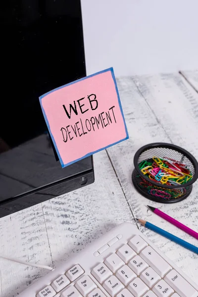 Handschrift tekst Web Development. Concept betekent werkzaamheden in verband met de ontwikkeling van een website voor het Internet Note-papier op zwart computerscherm in de buurt van toetsenbord en stationair. — Stockfoto