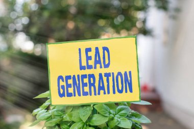 Lead Generation 'ı gösteren not yazılıyor. İş dünyasına bağlı potansiyel müşteriyi yetiştirmek için iş fotoğrafı sergisi. Sade kağıt yapışıp çimenli araziye yerleştirilmiş..