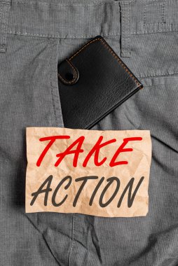 Kelime yazma metni Harekete Geç. Problemi çözmek için olumlu karar verme konsepti erkek pantolonunun içindeki küçük cüzdan nota kağıdının yanında..