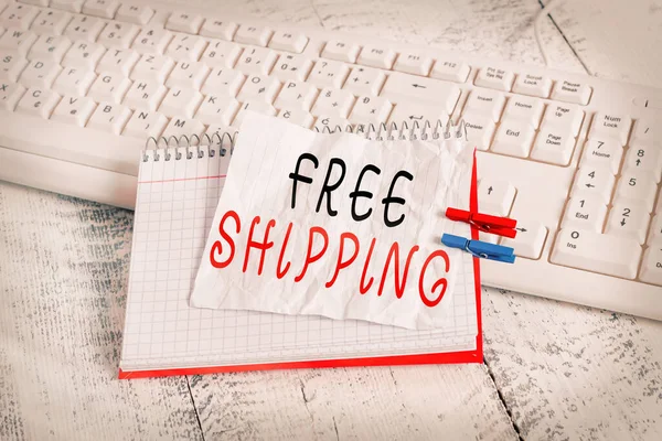 Tekst pisma Free Shipping. Koncepcja oznaczająca strategię sprzedaży detalicznej stosowaną przede wszystkim w celu przyciągnięcia większej liczby klientów notebook paper reminder clothespin pinned sheet white keyboard light wooden. — Zdjęcie stockowe