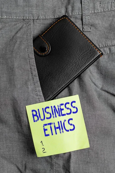 Writing note showing Business Ethics. Business photo showcasing appropriate policies which govern how a business operates Small wallet inside trouser front pocket near notation paper.