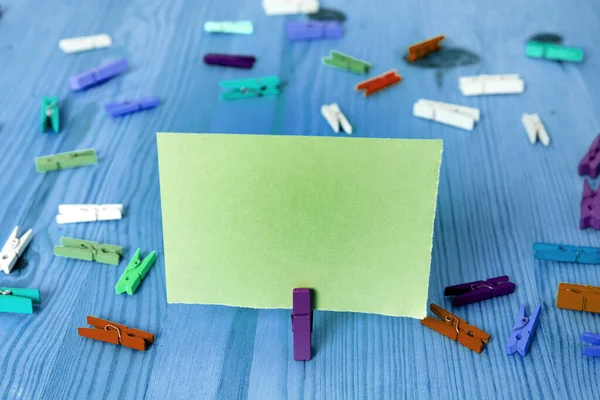 Rechthoekig vierkant gevormd gekleurd papier met wasknijper of papieren bal in een lichte achtergrond. Kleurrijke kreukelige notitie verspreid over de tafel. Kantoorbenodigdheden in een bureau. — Stockfoto