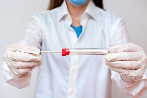 Personne portant des gants de robe médicale pour effectuer des expériences en laboratoire. Tenant le tube à essai de sang pour l'analyse d'état de santé — Photo