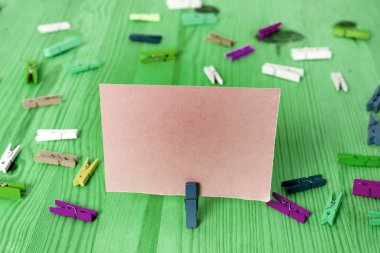 Dikdörtgen kare şekilli mandallı renkli kağıt ya da arka planda kağıt topu. Masanın etrafına renkli buruşuk notlar dağılmış. Ofis Malzemeleri Masada.