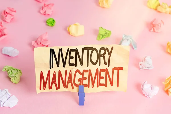 Writing note showing Inventory Management. Business photo showcasing supervision of noncapitalized assets and stock items Colored crumpled papers empty reminder pink floor background clothespin.