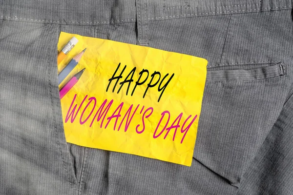 Sözcük yazma Mutlu Kadınlar Günü. Dünyanın dört bir yanındaki her bayanın özünü anmak için bir iş konsepti. Erkek iş pantolonlarının cebine ekipman ve sarı not kağıdı koymak için.. — Stok fotoğraf