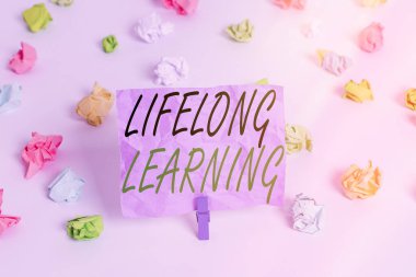 Kelime yazma metni ömür boyu öğrenme. Kişisel ya da mesleki nedenlerle bilgi arayışı için iş kavramı Renkli buruşmuş kağıtlar boş hatırlatıcı beyaz zemin çamaşır mandalı.