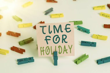 Tatil Zamanı 'nı gösteren bir not yazıyorum. İş fotoğrafı tanıtımı Keyfinize bakın Sevdiklerinizle Tatilinizi geçirin Renkli çamaşır iğnesi kağıtları Boş hatırlatıcı beyaz zemin arka plan ofisi.