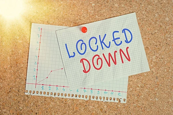 El yazısı yazısıyla "Locked Down". Konsept, kısıtlı alandan engellenen acil durum önlemi anlamına gelir. Mantar pano renk boyut kağıt raptiye raptiye raptiyesi ilan panosu. — Stok fotoğraf
