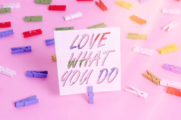 Szóírás szöveg Love What You do. Üzleti koncepció a szenvedély és a lelkesedés a munkahelyen Dedikáció odaadás Színes ruhacsap papírok üres emlékeztető rózsaszín padló háttér iroda pin. — Stock Fotó