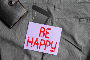 Mutlu Ol 'u gösteren bir not yazıyorum. İş fotoğrafı gösterimi, belli bir şey ya da olay aleti üzerinde zevk ve memnuniyet göstermektedir. Pantolonun ön cebinde cüzdanı olan akıllı telefon cihazı..