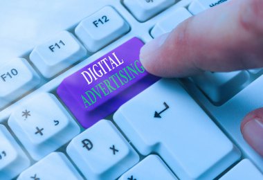 Metin işareti Dijital Reklamcılığı gösteriyor. İş dünyasının internet teknolojilerini beyaz anahtar alanının üzerinde boş not kağıdıyla beyaz pc klavyeyi tanıtmak için kullandığında kavramsal fotoğraf.