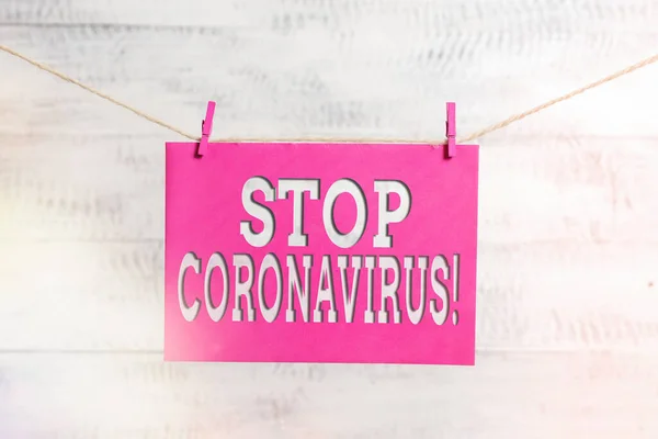 Kelime yazımı Coronavirus 'u durdurun. COVID19 vakalarının azaltılması için mücadele veren Hastalık Bilinci kampanyası iş konsepti Çamaşır ipi çamaşır ipi dikdörtgeni şekilli kağıt hatırlatıcı beyaz ahşap masa. — Stok fotoğraf