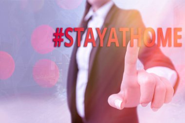 Hashtag 'in evde kaldığını gösteren bir not yazıyorum. İş fotoğraflarında, sosyal medyada Coronvirus salgınıyla ilgili bir trend etiketi gösteriliyor. İş dünyasındaki önemli ayrıntıları gösteren dokunmatik ekran dijital işaretleme.