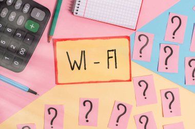 Wi-Fi 'yi gösteren bir mesaj. Kavramsal fotoğraf kablosuz yüksek hızlı internet ve ağ bağlantıları sağlar. Matematik şeyleri ve yazma ekipmanları pastel renkli arka plan üzerinde.