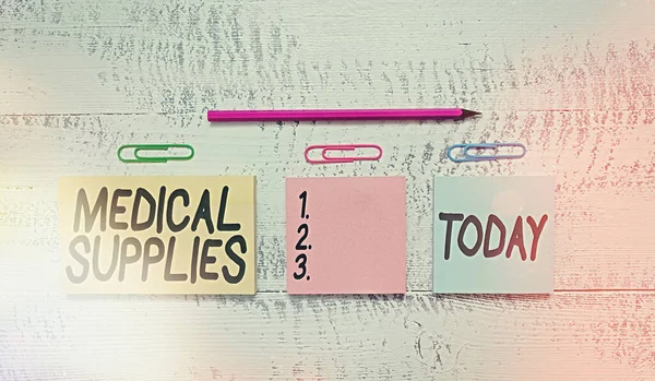 Text sign showing Medical Supplies. Conceptual photo Items necessary for treatment of illness or injury Multicolor blank notepads clips marker pencil wooden vintage background.