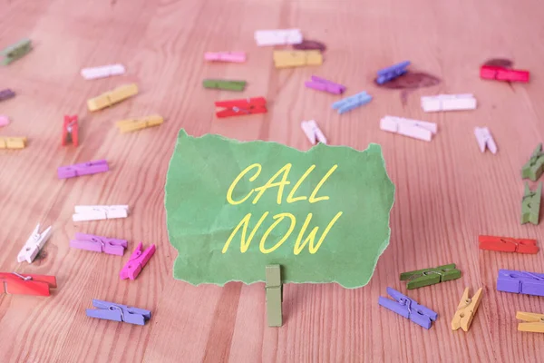 Написание текста Call Now. Бизнес-концепция для быстрого набора контактного номера, чтобы обсудить что-то цветные бумаги для одежды пустое напоминание деревянный пол фоновый офис . — стоковое фото