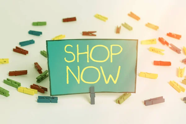 Word writing text Shop Now. Business concept for marketing banner which helps in gathering more potential buyer Colored clothespin papers empty reminder white floor background office. — Stock Photo, Image