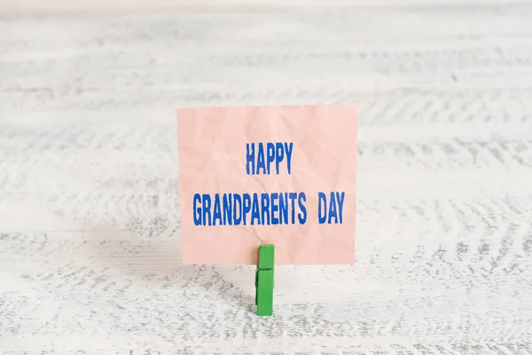 Kézírás üzenet Boldog nagyszülők napját. Koncepció jelentése Idősek vagy idősek ünnepe Zöld ruhacsap fehér fa háttér színes papír emlékeztető iroda ellátás. — Stock Fotó