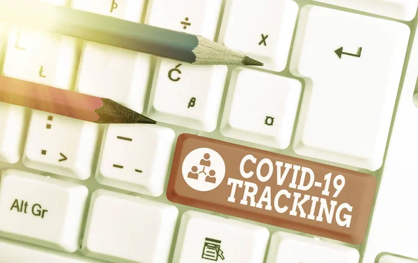 Znak tekstowy pokazujący Covid 19 Tracking. Koncepcyjne zdjęcie Charakterystyczny proces możliwych zarażonych osób Biała klawiatura PC z pustym notatnikiem nad białym kluczem przestrzeń kopiowania. — Zdjęcie stockowe