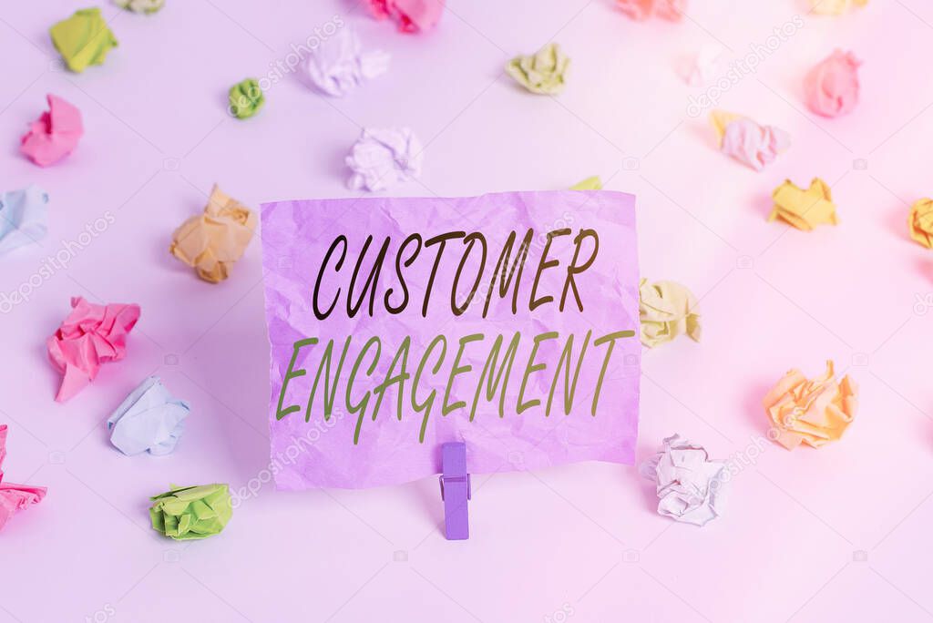 Word writing text Customer Engagement. Business concept for communication connection between a consumer and a brand Colored crumpled papers empty reminder white floor background clothespin.