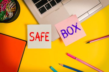 Güvenli Kutu 'yu gösteren bir not yazıyorum. Değerli belgelerin saklandığı metal bir emanet dolabını gösteren iş fotoğrafı. Laptop notları, konteyner notları, kalem işaretleri, renkli arka plan..