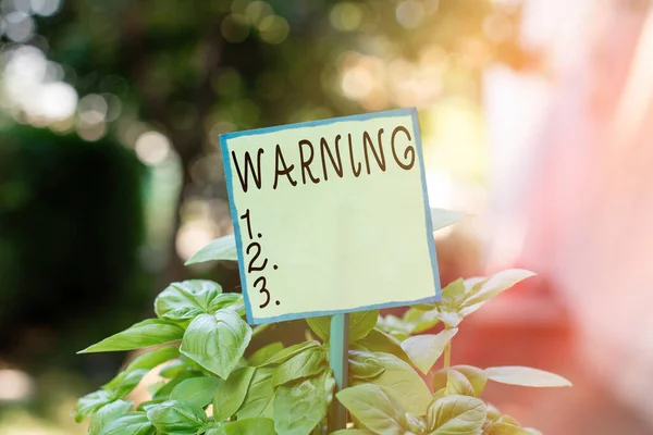 Escritura manual conceptual que muestra Advertencia. Texto de la foto de negocios declaración o evento que indica un peligro posible o inminente Papel liso adjunto a palo y colocado en la tierra herbácea . — Foto de Stock