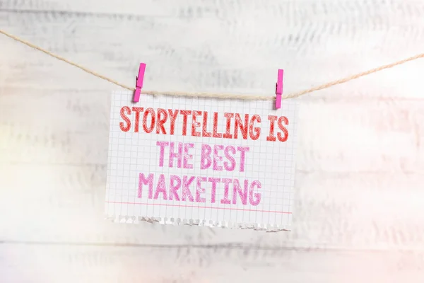 写便条表明讲故事是最好的营销。商务照片展示公司有效的营销方法日光浴服装别针矩形纸提醒白木桌. — 图库照片
