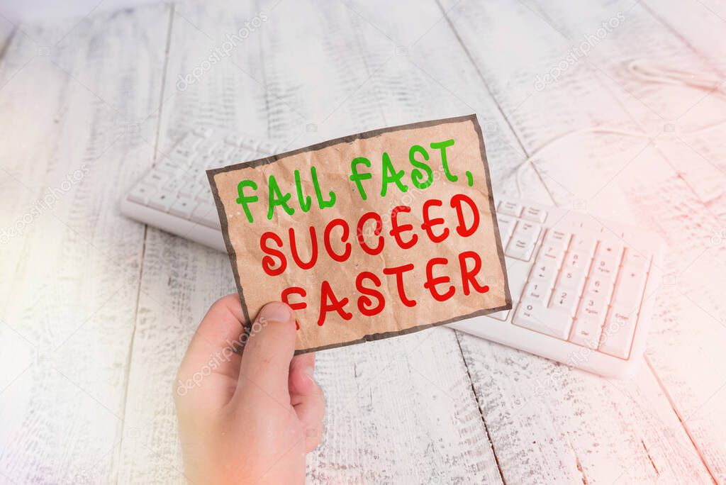 Conceptual hand writing showing Fail Fast, Succeed Faster. Business photo text failed attempt increases an eventual success Man holding colorful reminder square shaped paper wood floor.