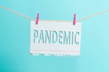 Mesaj pandemik olduğunu gösteriyor. Geniş bir alanda oluşan kavramsal fotoğraf nüfusun yüksek oranını etkiliyor Clothesline clothesline clothespin dikdörtgen şekilli kağıt hatırlatıcı beyaz ahşap masa.