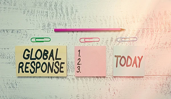 Text sign showing Global Response. Conceptual photo indicates the behaviour of material away from impact point Multicolor blank notepads clips marker pencil wooden vintage background.