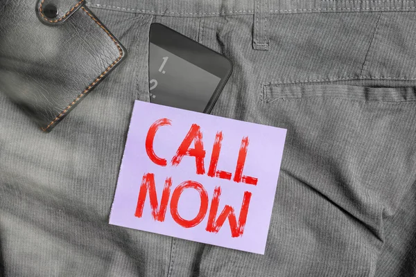 Writing note showing Call Now. Business photo showcasing Dialing a contact number immediately to discuss over something Smartphone device inside trousers front pocket with wallet.