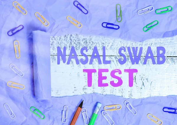 Text sign showing Nasal Swab Test. Conceptual photo diagnosing an upper respiratory tract infection through nasal secretion Rolled ripped torn cardboard placed above a wooden classic table backdrop.