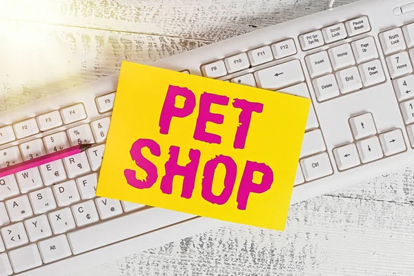 Text sign showing Pet Shop. Conceptual photo a retail business concentrating on selling domesticated animals White keyboard office supplies empty rectangle shaped paper reminder wood. — Stock Photo, Image