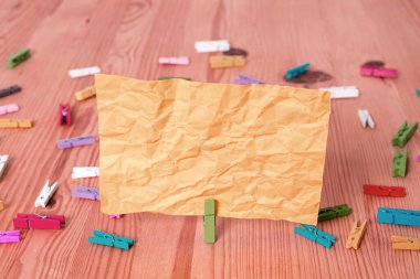 Dikdörtgen kare şekilli mandallı renkli kağıt ya da arka planda kağıt topu. Masanın etrafına renkli buruşuk notlar dağılmış. Ofis Malzemeleri Masada.