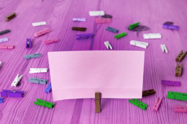 Dikdörtgen kare şekilli mandallı renkli kağıt ya da arka planda kağıt topu. Masanın etrafına renkli buruşuk notlar dağılmış. Ofis Malzemeleri Masada.